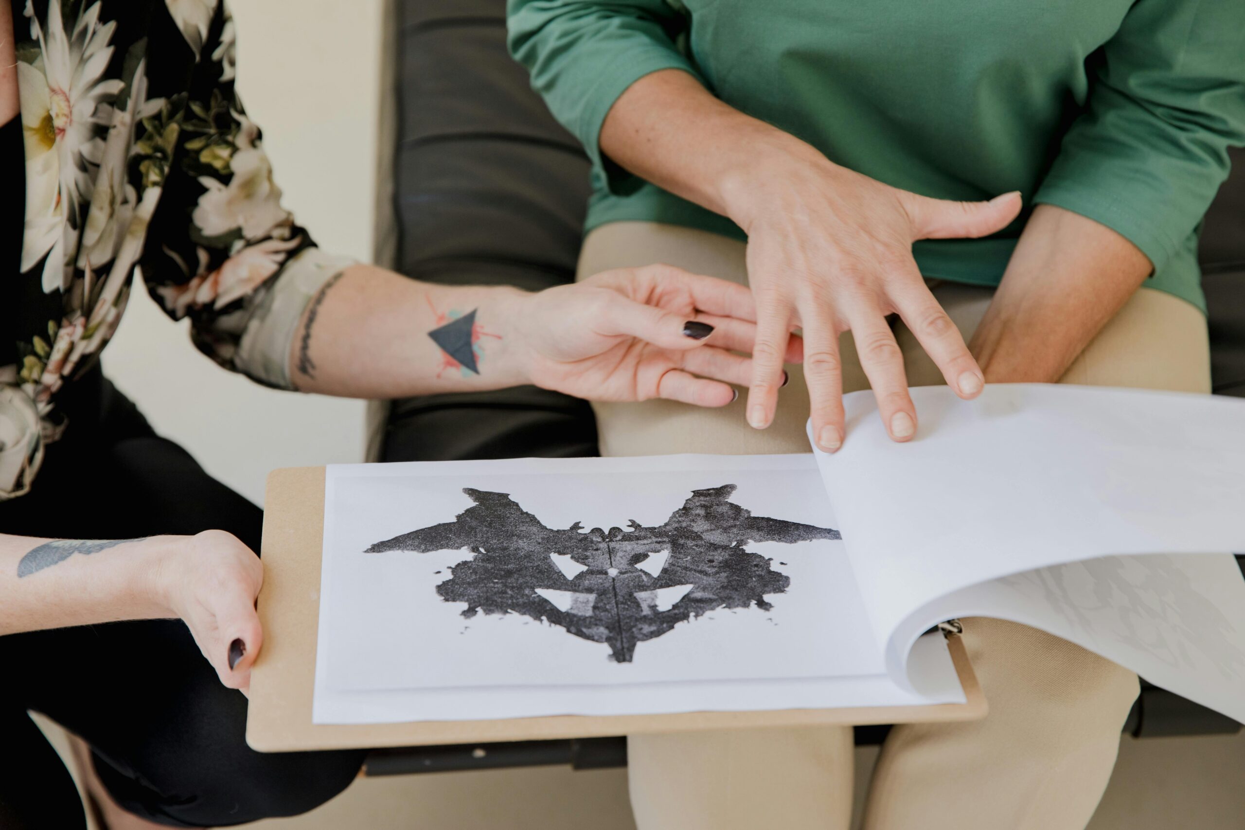Close-up of two women discussing a Rorschach inkblot test during a therapy session.